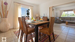 A dining area with wicker chairs, a wooden table, and a colorful striped rug. - Villa AURORA by Abahana Villas (Benissa)
