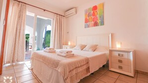 A bedroom with a bed, bedside tables, a painting, and a view through a door. - Villa AURORA by Abahana Villas (Benissa)