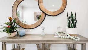 A table with two wooden rings, a potted plant, a decorative item, and a book. - Beautiful Tropical Retreat Near Fort Lauderdale Beach, Las Olas & Top Attractions (Fort Lauderdale)