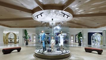 A modern interior with a central display featuring mannequins and a disco ball.