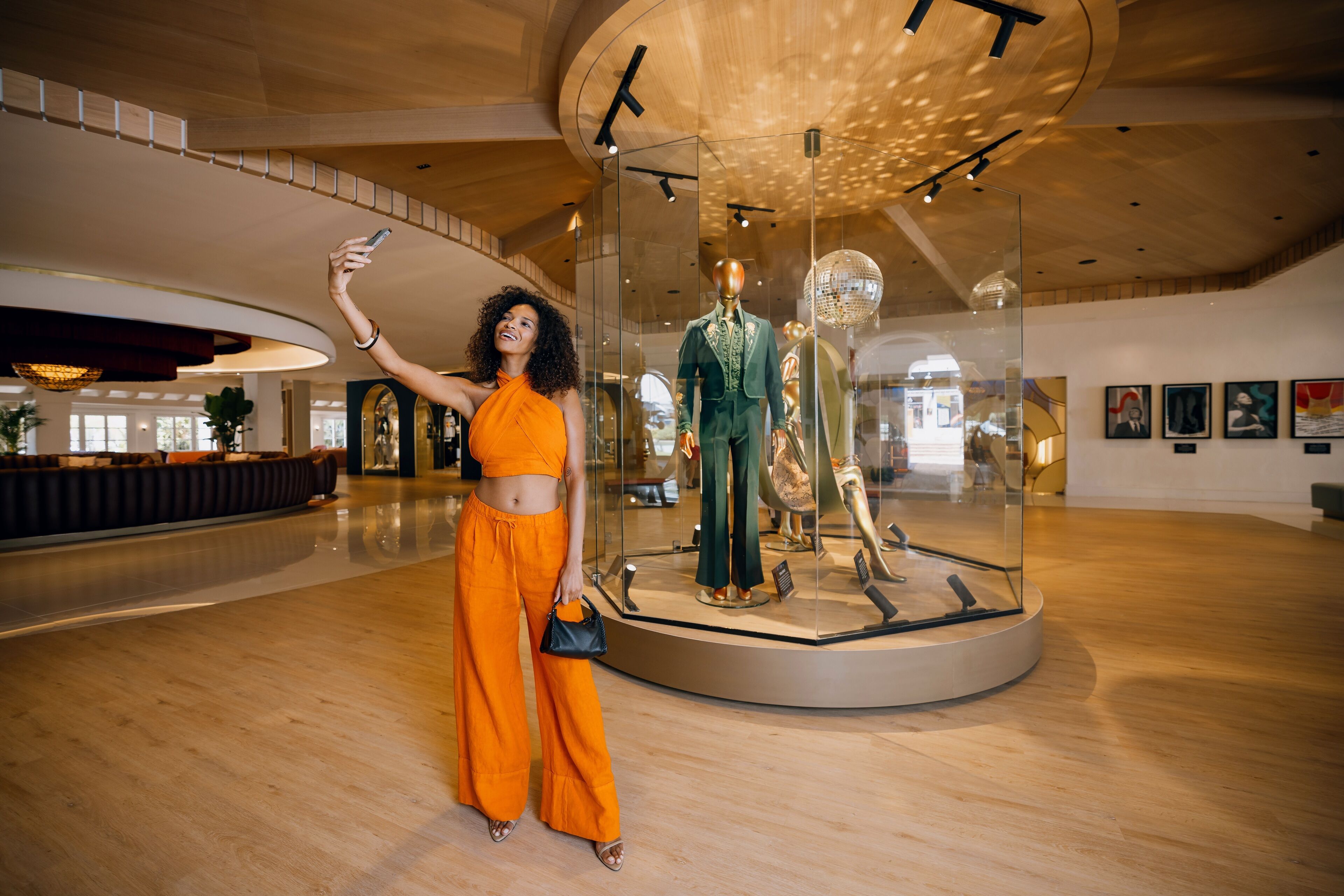 Een ruime binnenruimte met een glazen vitrine waarin mannequins staan.