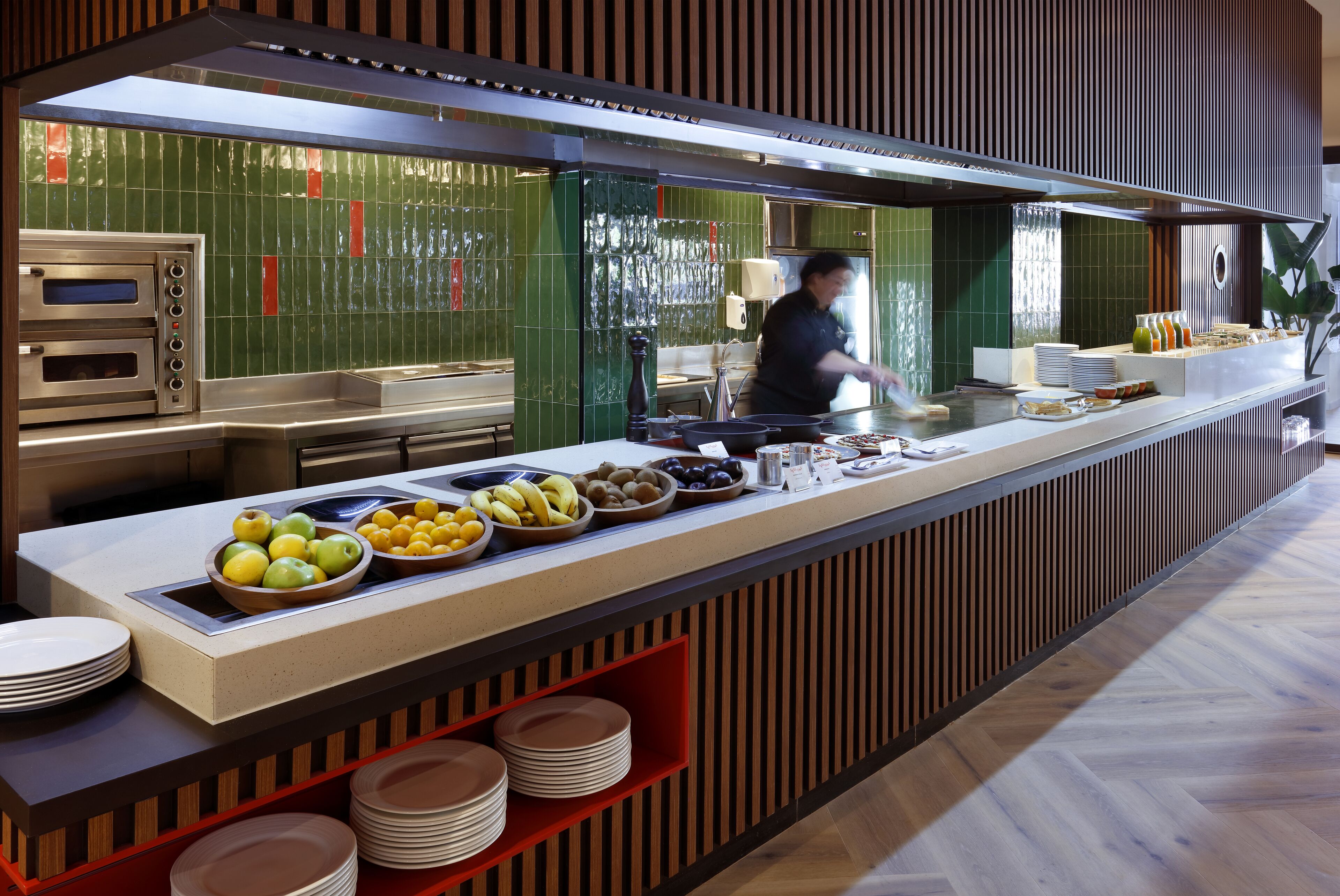 A buffet setup with multiple food stations, including a fruit bowl and a variety of dishes.