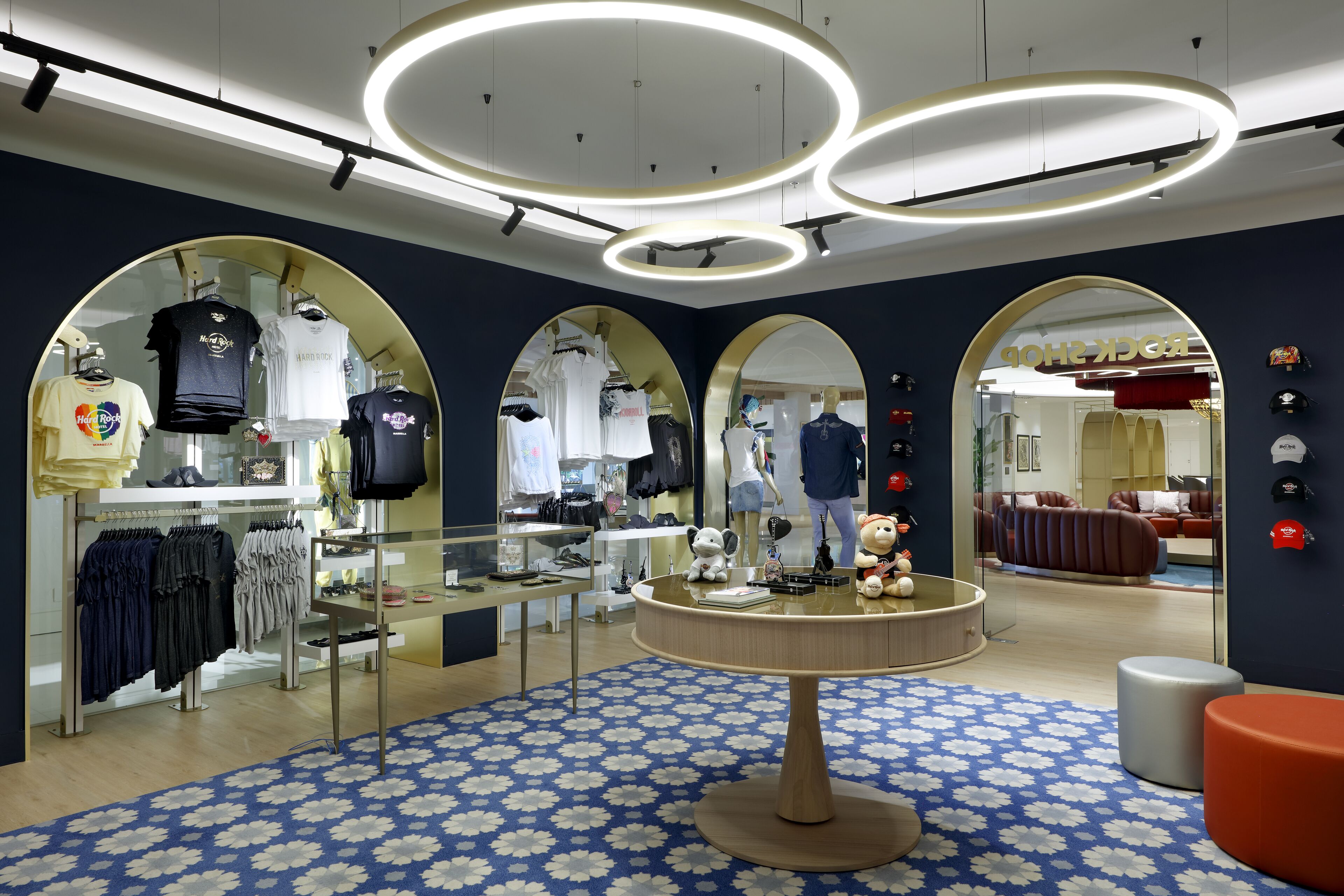 A modern retail store with circular ceiling lights, mirrored walls, and a patterned floor.