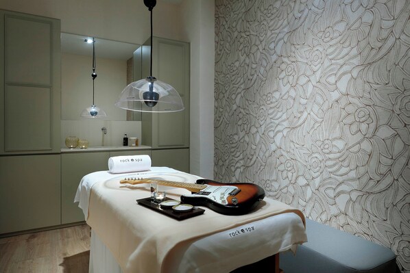 A room with a bed, a guitar, and a towel labeled "rock spa".