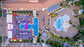 An aerial view of a hotel with a central pool area, multiple lounge areas, and a prominent Hard Rock Hotel sign.