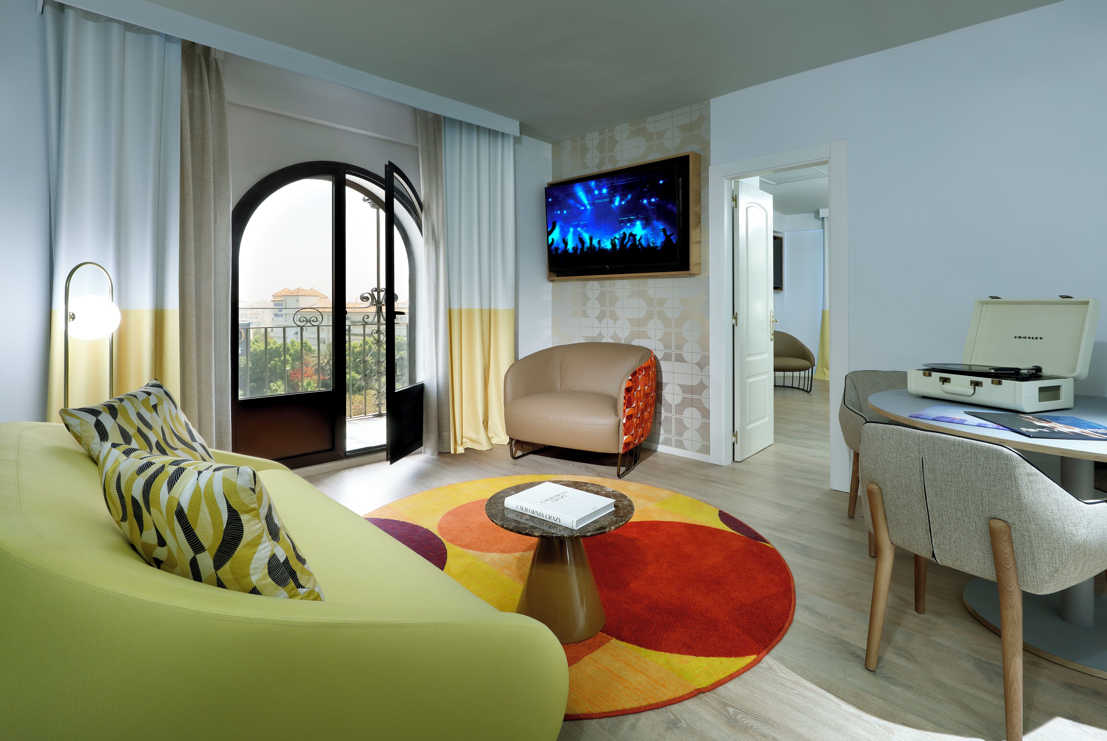 Una sala de estar moderna con un sofá, una mesa de centro, un televisor y un comedor.
