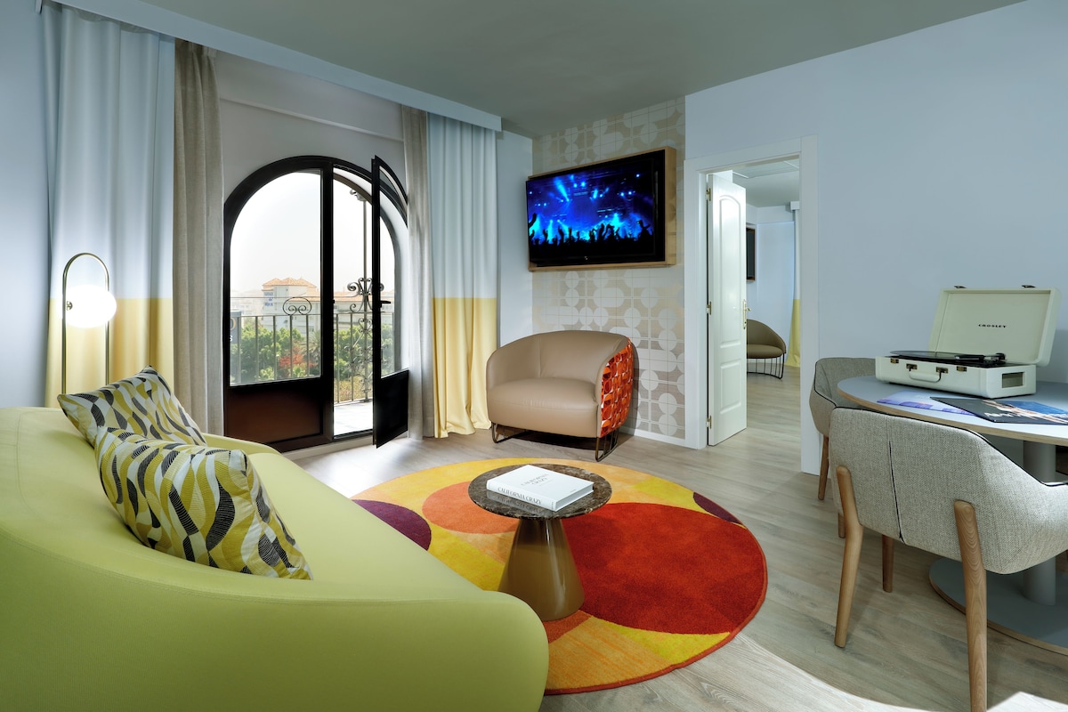 Una sala de estar moderna con un sofá, una mesa de centro, un televisor y un comedor.