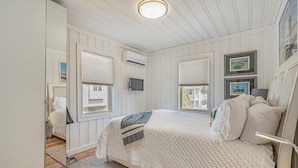 A bedroom with a large bed, white walls, and a ceiling fan. - Coconut Flats Duplex- Upstairs- (North Myrtle Beach)