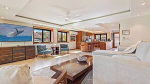 A spacious living room with a large painting, a wooden coffee table, and a sofa.