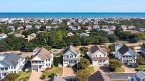 A coastal residential area with houses featuring two-story structures, some with balconies, and a clear view of the ocean. - Beachin Up With The Jones's: Private Pool, Dogs OK (Corolla)