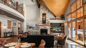 A spacious living area with a fireplace, a television, and a dining area with a wooden table and chairs. - Private Indoor Pool! The Northwest's most unique vacation experience!! (Cle Elum)