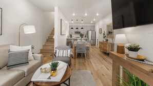 Un salon moderne avec un canapé, une table basse et un coin repas.