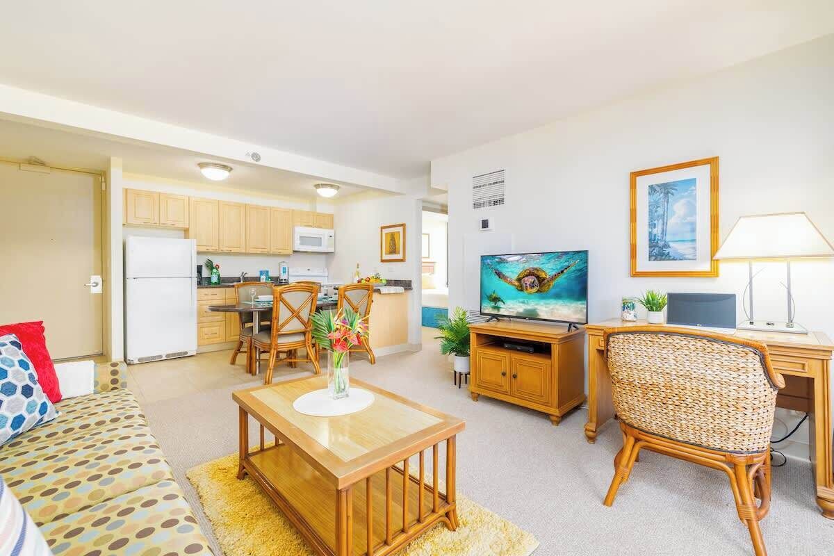 Un espacio habitable compacto con comedor, cocina y televisor.