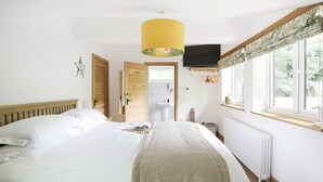 Ein Schlafzimmer mit einem Bett, einem Fenster mit Blick, einem Heizkörper und einem an der Wand befestigten Fernseher.