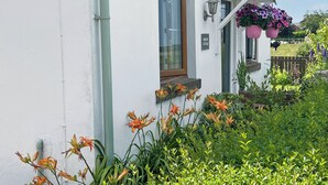 A white cottage with a window, a door, and a small porch area. - Boasting a private garden, stunning views and ample parking. (St. Michael&rsquo;s on Wyre)