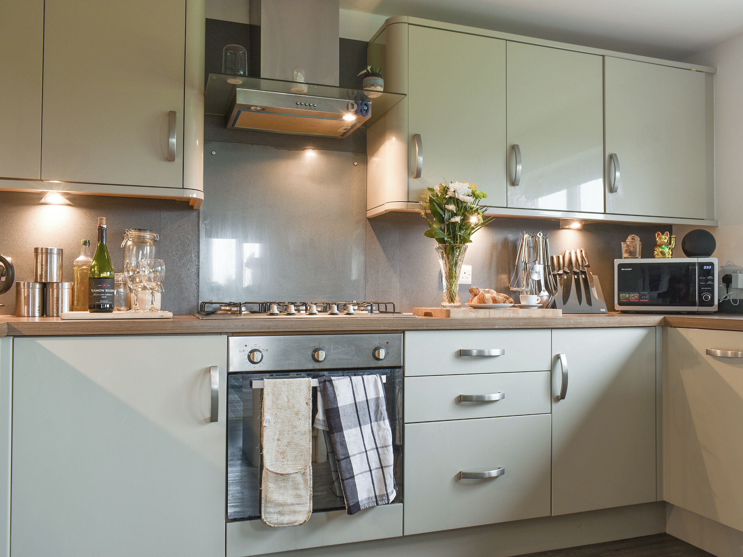 A modern kitchen with a gas stove, oven, microwave, and stainless steel cabinets.