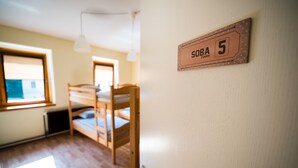 Un dormitorio con literas, una ventana y un cartel que indica 'SOBA room 5'.