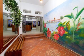 A room with a mural, wooden benches, and a tiled floor. - Hotel Jardines Evans By Geh Suites (Mompos)