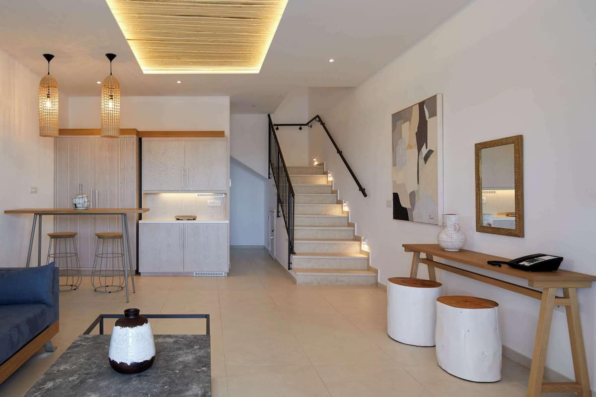 Un intérieur moderne comprenant un escalier, une cuisine et un coin salon.