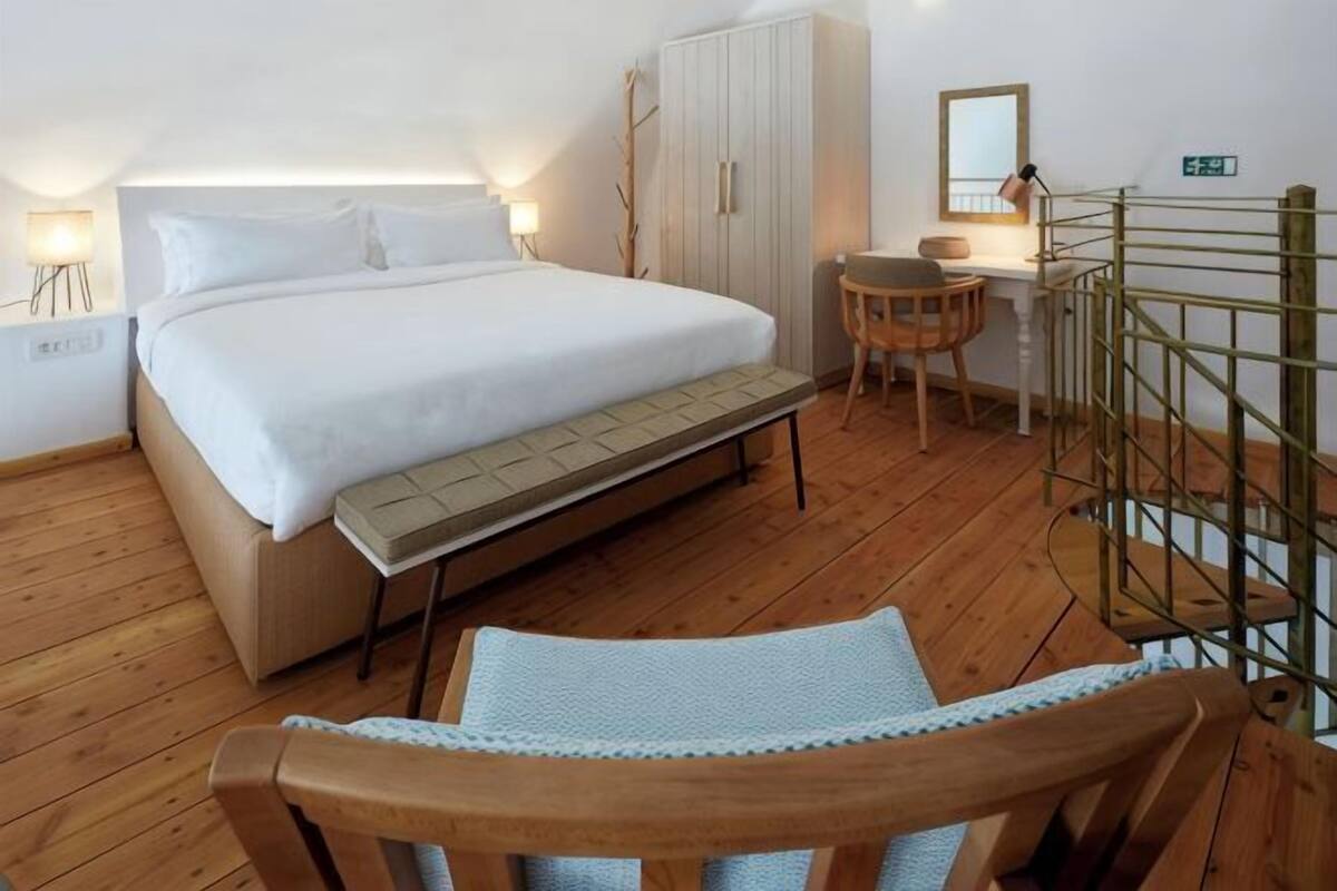 Une chambre à coucher comprenant un lit, une table de chevet, une chaise, une armoire et un bureau avec une chaise.