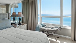 A hotel room with a large window, a bed, a nightstand, and a chair. - Beach Front | Water Views | Pool | Tennis | Hot Tub | Free Beach Chairs (Miramar Beach)