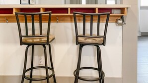 A bar area with two stools and a wooden counter.