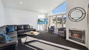 A modern living room with a leather sofa, a round coffee table, and a fireplace.