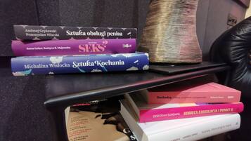 A stack of books on a black table.