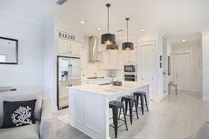 Enjoy cooking in this well-equipped kitchen with a central island, microwave, and white cabinetry.