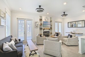 Relax in this inviting living room with a large sofa, coffee table, and fireplace, perfect for unwinding and socializing.