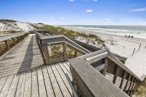 Walk along the boardwalk to the pristine beach with a clear view of the ocean and dunes.