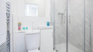 Un baño con inodoro, lavabo y ducha.