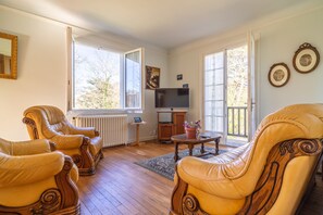 Relax in this spacious living room with a large television, two comfortable armchairs, and a coffee table.