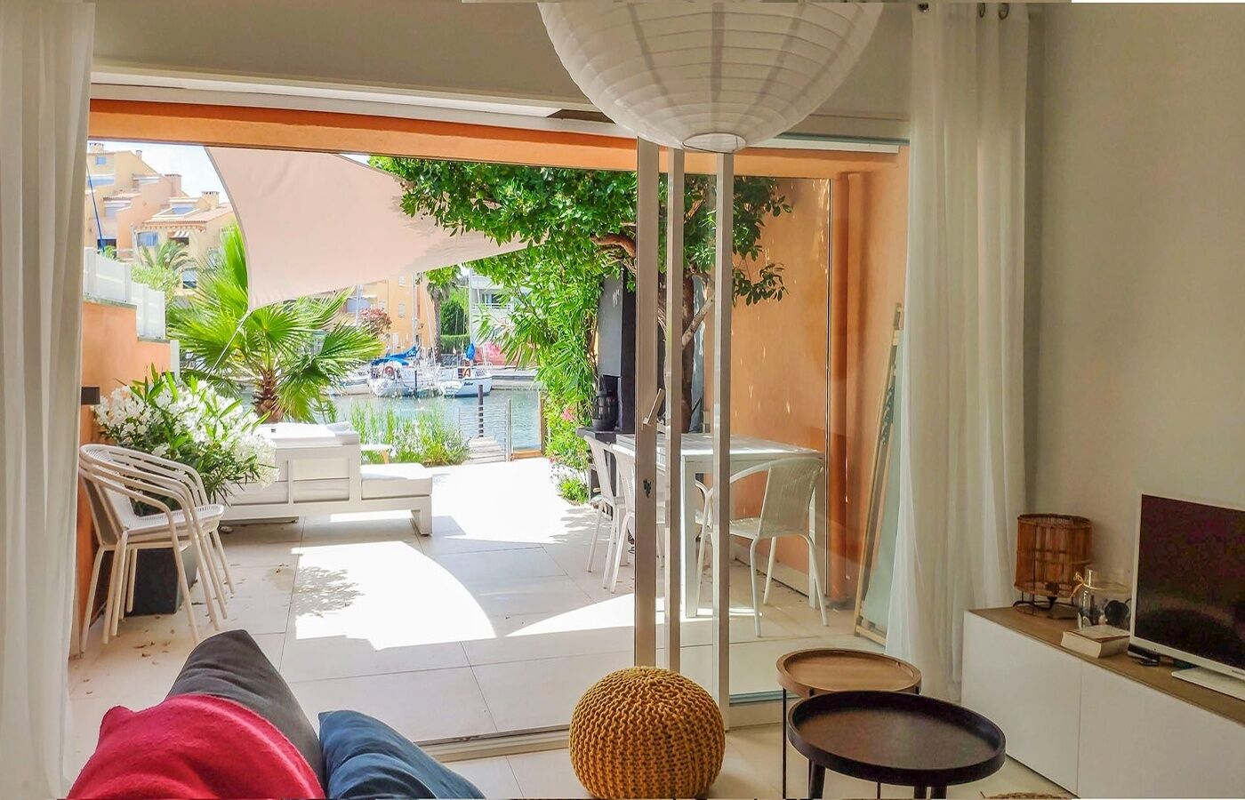 A modern living room with a large sliding glass door leading to an outdoor patio area.
