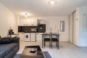 Um espaço compacto com cozinha compacta, área de jantar e sofá.