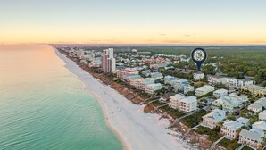 An aerial view of a coastal area with a beach, residential buildings, and a prominent hotel with a large structure and multiple stories. - Aces High|Private Beach Access|Private Pool|Golf Cart (Santa Rosa Beach)