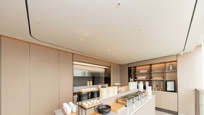 Una cafetería moderna y minimalista con mostrador de mármol, recipientes de comida ordenados y un diseño limpio y contemporáneo.
