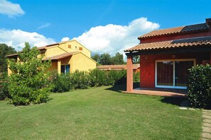 A residential property with a well-maintained lawn, a patio area, and a red-roofed structure. - Spacious Corsica Stay for 8 near Beach (Ghisonaccia)