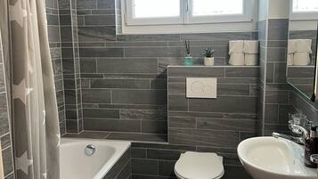 Combined shower/bathtub, hair dryer, towels, toilet paper