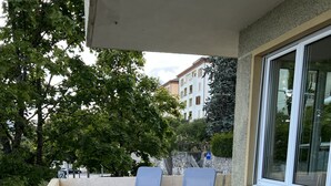 Un balcon avec deux fauteuils bleus et une table en bois.