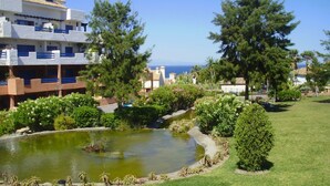 Un hotel amb piscina, envoltat de vegetació i vistes al mar.
