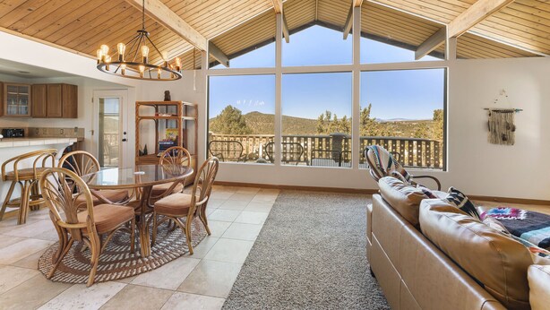 A spacious living area with a large window offering a view of a hilly landscape. - Mountain Views at Rim Country Chalet  (Payson)
