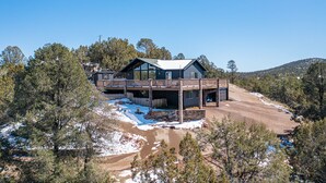 A modern two-story house with a balcony, surrounded by trees and a snowy landscape. - Mountain Views at Rim Country Chalet  (Payson)