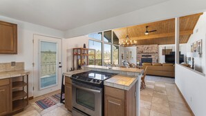 A modern kitchen with a central island, a built-in oven, and a large window. - Mountain Views at Rim Country Chalet  (Payson)