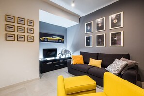 Relax in this stylish living room with a flat-screen TV, comfortable seating, and beautiful framed artwork.