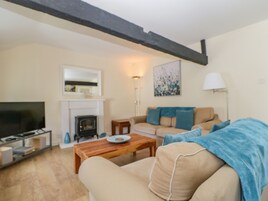 A living room with a fireplace, sofa, and television.