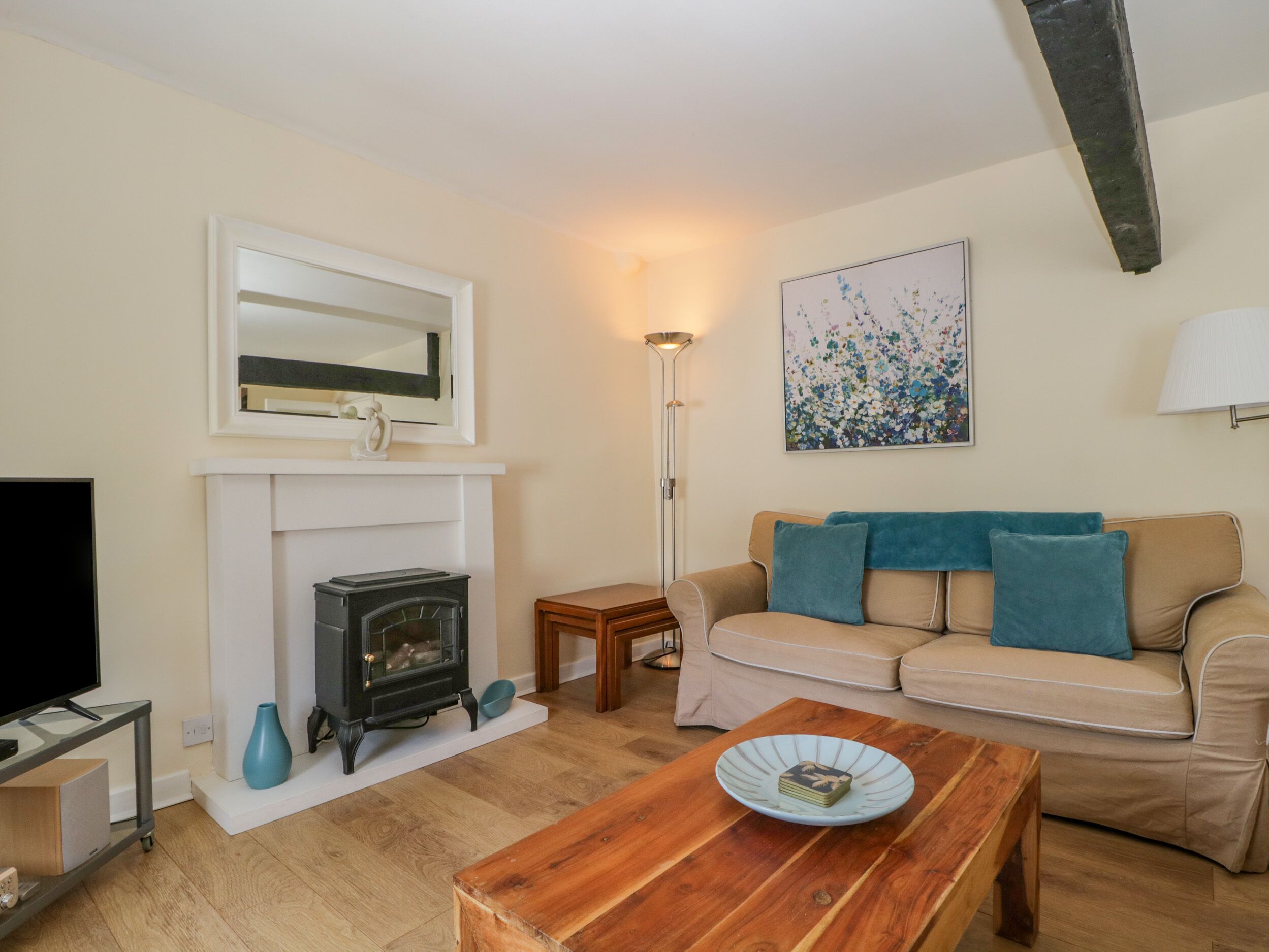 A living room with a fireplace, a sofa, a coffee table, and a television.