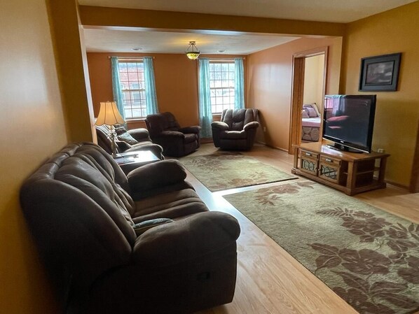 A living room with a sofa set, a television, and a wooden cabinet.