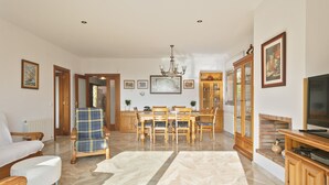 A spacious living room with a dining area, a fireplace, and a television.