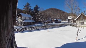 A snow-covered landscape with wooden cabins and a clear blue sky. - "Little House on the Prairie" with modern plumbing! (Coon Valley)